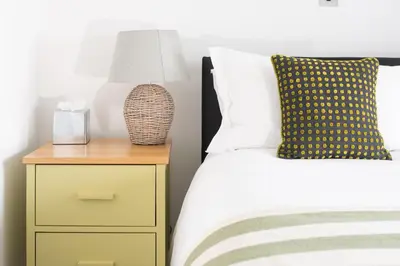 a bedroom with a bed and a nightstand with a lamp at The St Enodoc Hotel in Wadebridge