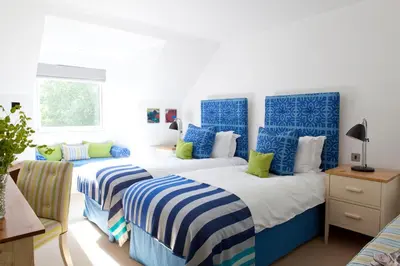 two beds in a room with blue and white at The St Enodoc Hotel in Wadebridge