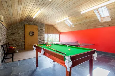 a pool table in a room with a red wall at Cargurra Farm in Boscastle