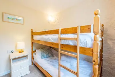 a bunk bed room with two bunk beds in a house at Cargurra Farm in Boscastle