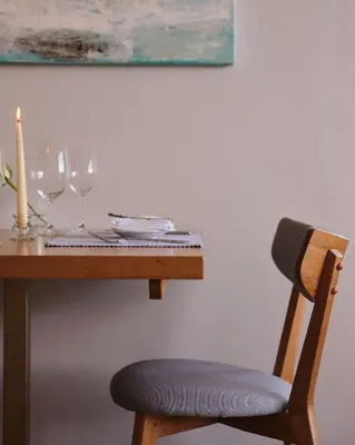 a wooden table with a candle and wine glasses at Boskerris Hotel in St Ives
