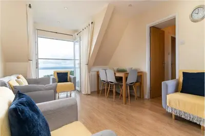 a living room with a couch and a table at Number 9 Rosemorran in St Ives