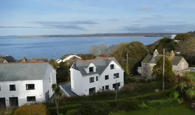 an aerial view of a white house with the ocean in the background at Number 9 Rosemorran in St Ives