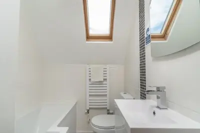 a bathroom with a toilet and a sink and a mirror at Number 9 Rosemorran in St Ives