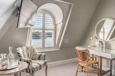 a room with a chair and a desk and a window at Harbour Hotel Fowey in Fowey