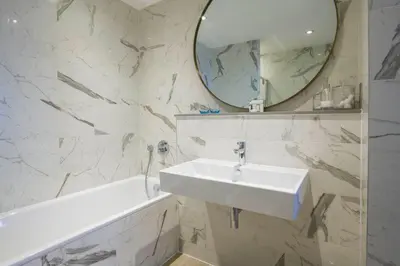 a white bathroom with a sink and a mirror at Harbour Hotel Fowey in Fowey