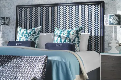 a bedroom with a bed with blue and white pillows at Harbour Hotel Fowey in Fowey