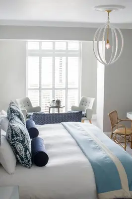 a bedroom with a large bed with blue and white pillows at Harbour Hotel Fowey in Fowey