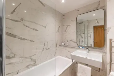 a bathroom with a tub and a sink and a mirror at Harbour Hotel Fowey in Fowey