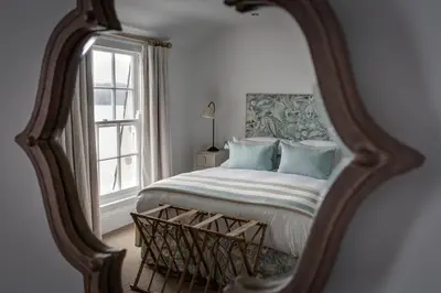 a bedroom with a bed and a mirror at The Idle Rocks in Saint Mawes