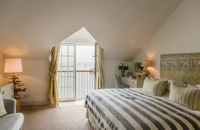 a bedroom with a bed and a large window at The Idle Rocks in Saint Mawes