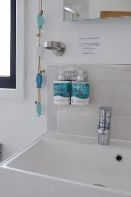a bathroom sink with two containers of laundry detergent at Porth Beach Hotel in Newquay