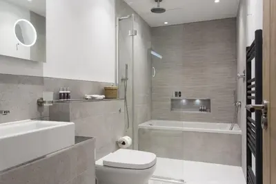 a bathroom with a toilet and a sink and a tub at Porth Beach Hotel in Newquay
