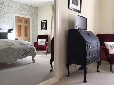 a bedroom with a television on top of a dresser at Coswarth House with breakfast at Rick Stein's in Padstow