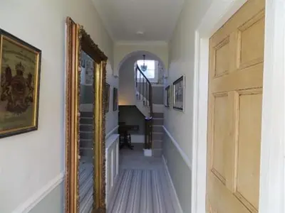 a hallway with a mirror and stairs in a house at Coswarth House with breakfast at Rick Stein's in Padstow