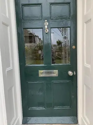 a green door with a reflection in a window at Coswarth House with breakfast at Rick Stein's in Padstow