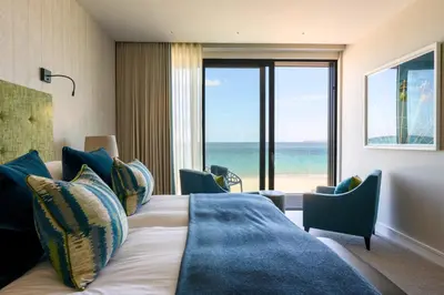 a bedroom with a bed with a view of the ocean at Carbis Bay and Spa Hotel in St Ives