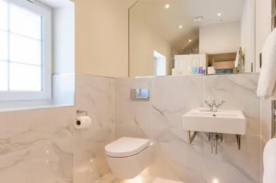 a white bathroom with a toilet and a sink at Carbis Bay and Spa Hotel in St Ives
