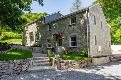 an old stone house with a stone wall at Carbis Bay and Spa Hotel in St Ives