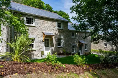 an old stone house with a yard at Carbis Bay and Spa Hotel in St Ives