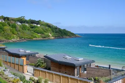 a row of houses on a beach next to the ocean at Carbis Bay and Spa Hotel in St Ives