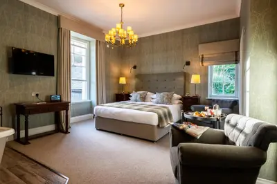 a hotel room with a bed and a chandelier at Carbis Bay and Spa Hotel in St Ives