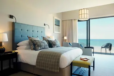 a bedroom with a large bed with a view of the ocean at Carbis Bay and Spa Hotel in St Ives