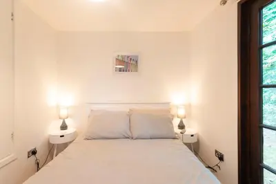 a bedroom with a white bed with two lamps at Cornwall holiday homes in Hayle