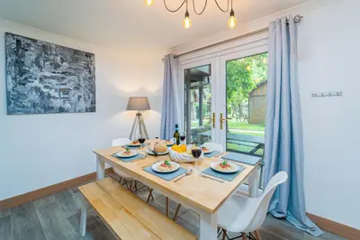 a dining room with a wooden table and chairs at Cornwall holiday homes in Hayle