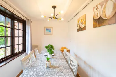 a dining room with a long table with white chairs at Cornwall holiday homes in Hayle