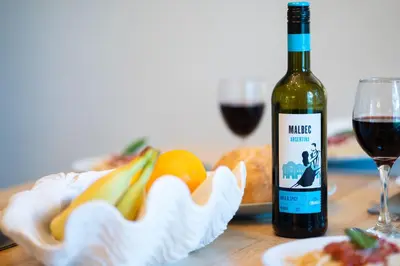a bottle of wine next to a glass of red wine at Cornwall holiday homes in Hayle