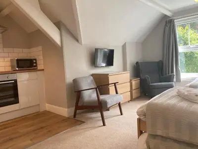 a bedroom with a bed and a chair in a room at Braemar in Falmouth