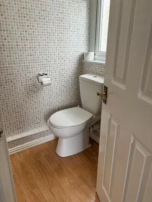 a bathroom with a white toilet and a window at Braemar in Falmouth