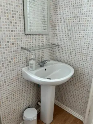 a bathroom with a white sink and a mirror at Braemar in Falmouth