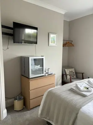 a bedroom with a bed and a tv on a dresser at Braemar in Falmouth