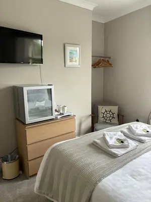 a bedroom with a bed and a tv on a dresser at Braemar in Falmouth