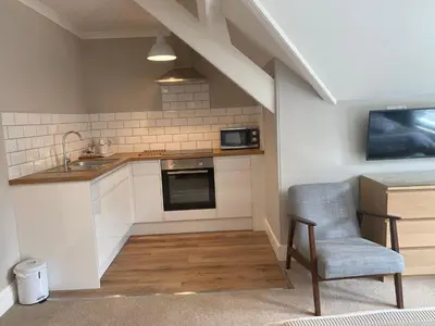 a kitchen with a sink and a chair in a room at Braemar in Falmouth