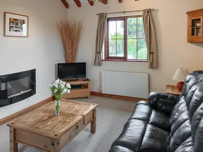 a living room with a couch and a coffee table at Beckaveans Stable in Jacobstow