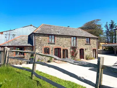 an old stone house with a wooden fence at Beckaveans Granary in Jacobstow