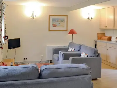 a living room with two blue couches and a tv at Every in Saint Kew