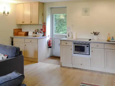 a kitchen with white cabinets and a stove top oven at Every in Saint Kew