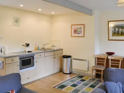 a kitchen with white cabinets and a counter top at Every in Saint Kew