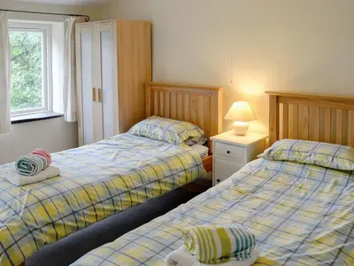 a bedroom with two beds and a lamp in it at Every in Saint Kew