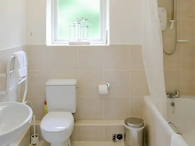 a bathroom with a toilet and a sink and a window at Every in Saint Kew