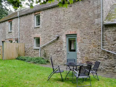 a table and chairs in front of a brick building at Every in Saint Kew