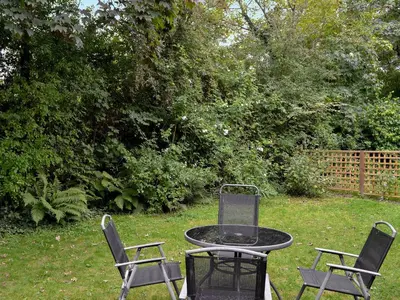 three chairs and a table in a yard at Every in Saint Kew