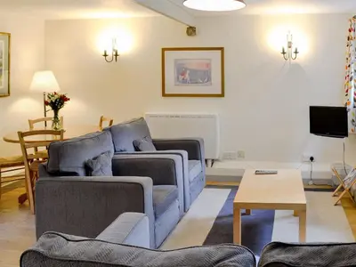 a living room with two couches and a table at Paget in Saint Kew