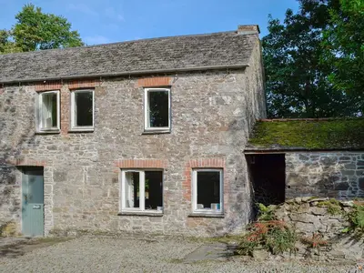 an old stone house with a green roof at Paget in Saint Kew