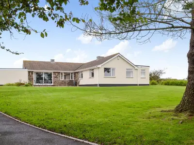 a white house with a large yard at Tregoona in Crantock