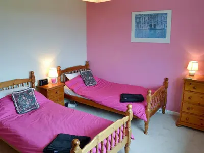 two beds in a room with pink sheets at Tregoona in Crantock